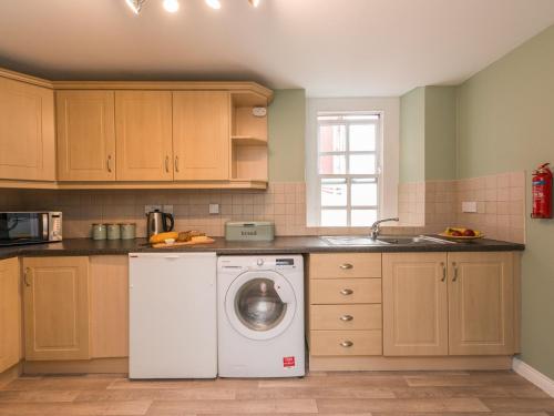 a kitchen with a white washing machine in it at Hamilton House Holiday Apartment in Killyleagh