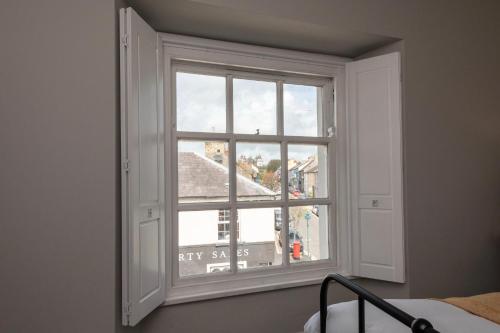an open window with a view of a building at Hamilton House Holiday Apartment in Killyleagh