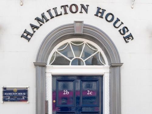 a door to a building with a sign above it at Hamilton House Holiday Apartment in Killyleagh