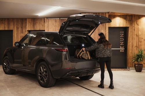 a woman standing in the open trunk of a car at Luxury Chalet Milé in Ortisei