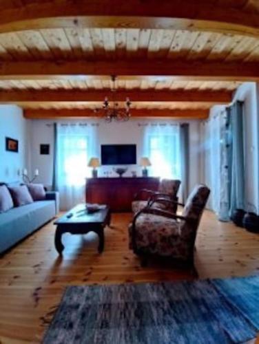 a living room with a couch and a table at Panorámaház Lovason in Lovas