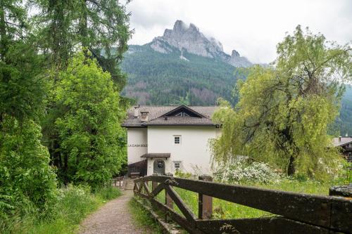 a house in the mountains with a fence at Chateau Ciasa Soldà Luxe Saslonch in Vigo di Fassa