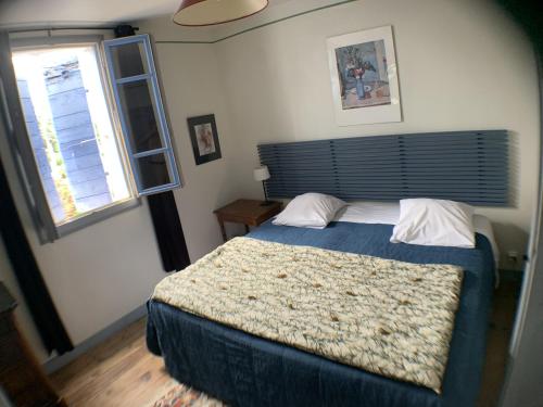 une chambre avec un grand lit et une fenêtre dans l'établissement Mas Valentine, à Roquemaure