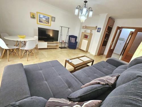 a living room with a blue couch and a table at ALMERIA CENTRO y CONFORT in Almería