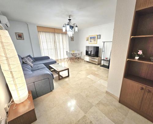 a living room with a blue couch and a television at ALMERIA CENTRO y CONFORT in Almería
