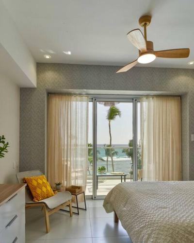a bedroom with a bed and a view of the ocean at Aquarella Sunset Caribbean Beachfront Gataway in La Puntica de Juan Dolio