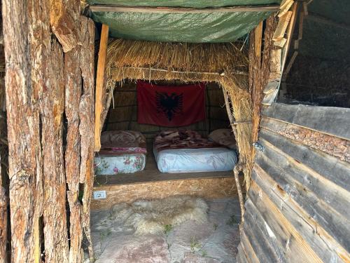 a wooden cabin with two beds in the inside at Camping Lekdushi - Shehu in Tepelenë