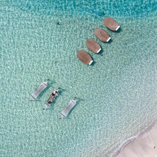four flip flops in the water on a beach at Rest Sea Resort Koh Kood in Ko Kood