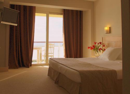 a hotel room with a bed and a large window at Hôtel Campo Dell'oro in Ajaccio