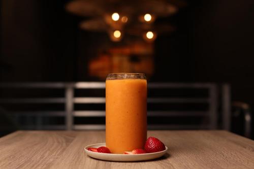 a glass of orange juice and strawberries on a table at Smart Brickell Hotel in Miami
