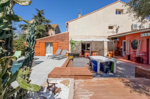 un patio extérieur avec une table et des chaises dans l'établissement Villa Moderne avec Piscine à Vinassan, à Vinassan