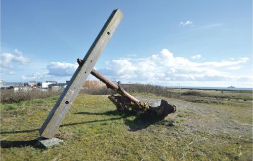 a wooden pole sitting on the grass in a field at Stunning Home In Rømø With Wifi in Havneby