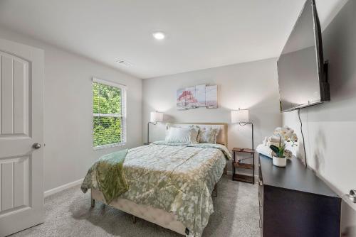 Un dormitorio blanco con una cama y un televisor. en Happy Hideaway by Deity Villas, en Atlanta