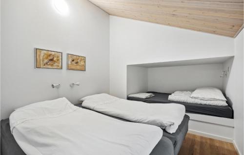 two beds in a room with white walls at Awesome Home In Tarm With Sauna in Tarm