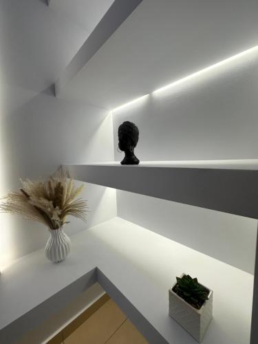 a room with white shelves with a vase and a statue at Eutixias House in Sfakaki