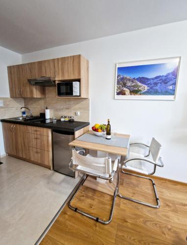 a kitchen with a table and chairs in a room at Apartamenty INTERDOM in Zakopane