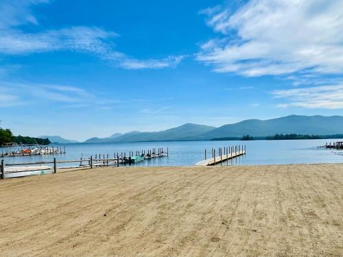 a dock on a lake with mountains in the background at Waters Edge Lodge in Lake George