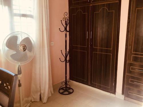 a room with a fan next to a closet at Nam Garden in Kisumu