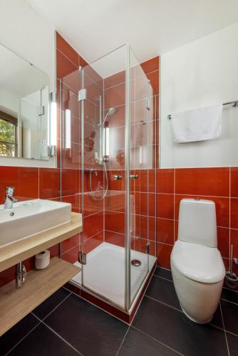 a bathroom with a shower and a toilet and a sink at Landhotel Zur Schmiede in Göhren-Lebbin