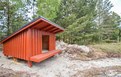a small redshed sitting on the sand in the woods at Holiday Home Romo Lxx in Toftum