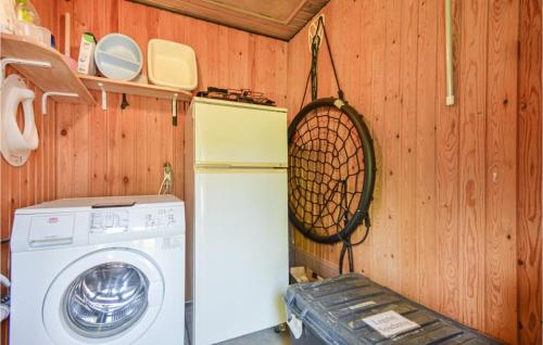 a kitchen with a washing machine and a wooden wall at Holiday Home Romo Lxx in Toftum