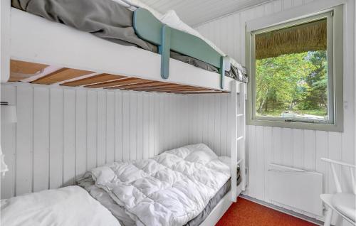 a bunk bed in a white room with a window at Holiday Home Romo Lxx in Toftum