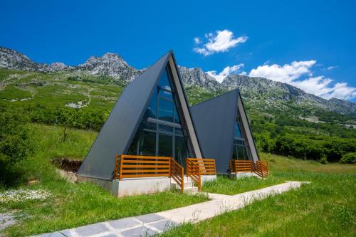 una casa en una colina con montañas al fondo en Arditi's Chalets, en Bogë
