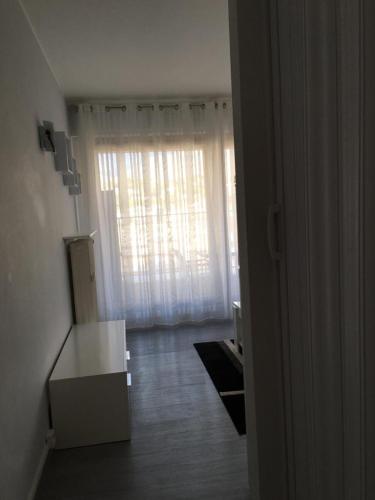 un salon avec une grande fenêtre et une table dans l'établissement Studio Hernani, à Roquebrune-Cap-Martin