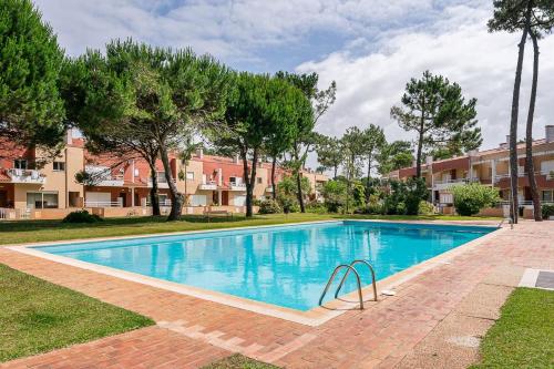 a swimming pool in a yard with trees and buildings at GuestReady - A paradisíac stay in Fão in Fão