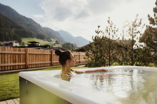 a woman is sitting in a bath tub at Luxury Chalet Milé in Ortisei