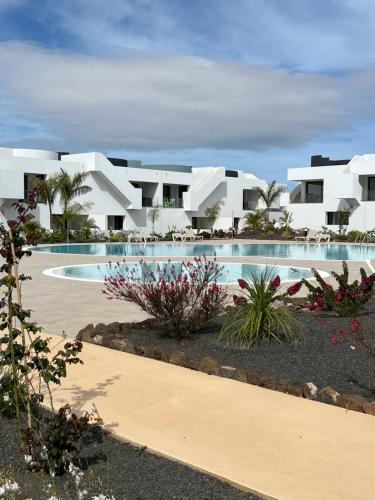 a view of a resort with a swimming pool at Casita Oliva - Piso de diseño en Fuerteventura in La Oliva