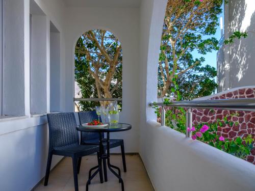 a small table and two chairs on a balcony at Smaragdi in Perivolos