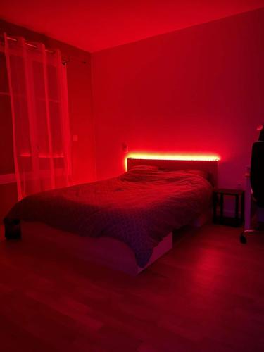 - une chambre rouge avec un lit avec une lumière rouge dans l'établissement Appartement bordeaux proche de la plage, à Pont-de-la-Maye