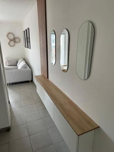 une cuisine avec un comptoir avec trois miroirs sur le mur dans l'établissement L'escale Charmant Studio Villeurbanne La Soie, à Villeurbanne