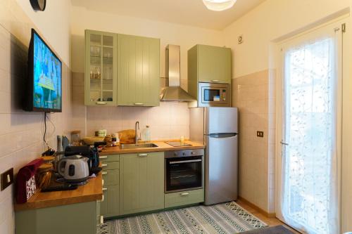 a kitchen with green cabinets and a refrigerator at B&B Casa al Mare in Marano Lagunare
