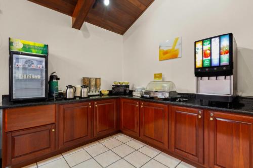 a kitchen with wooden cabinets and a counter with a refrigerator at Suburban Studios in Altoona