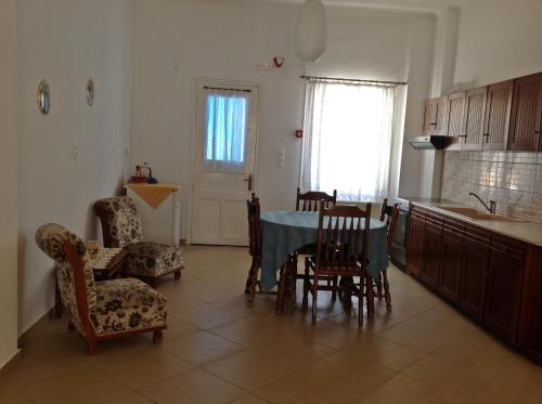 a kitchen and dining room with a table and chairs at Papanikola House 1 in Astypalaia Town