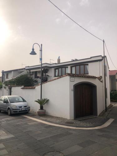 a car parked in front of a white building at B&B su Coccu in Zeddiani