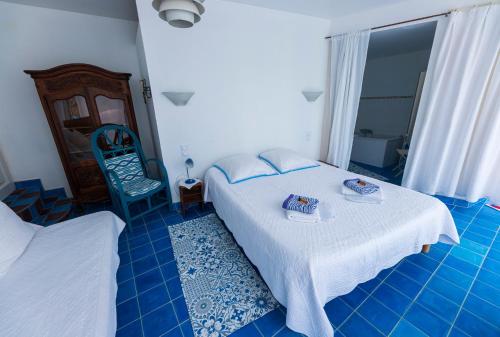 a bedroom with a white bed and a blue floor at Le Jas Du Colombier in Moustiers-Sainte-Marie