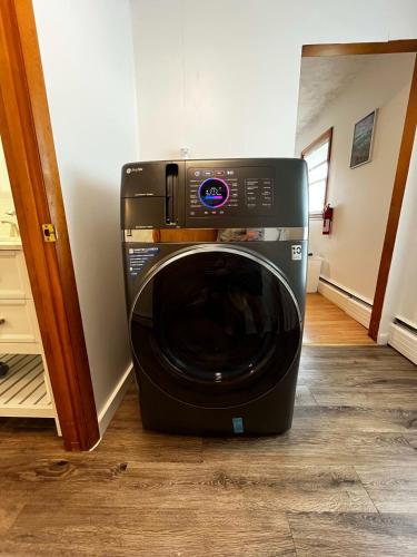 a black washing machine sitting in a room at Whimsical apartment near downtown Winooski in Winooski