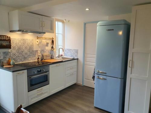 La cuisine est équipée d'un réfrigérateur et d'un évier. dans l'établissement Les Bonnes Ondes - Chalet breton bord de mer - Baie Mont St Michel, à Saint-Benoît-des-Ondes