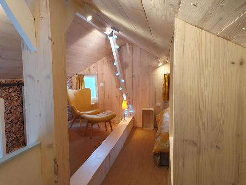 - une chambre avec un lit et une chaise dans une maison dans l'établissement Les Bonnes Ondes - Chalet breton bord de mer - Baie Mont St Michel, à Saint-Benoît-des-Ondes