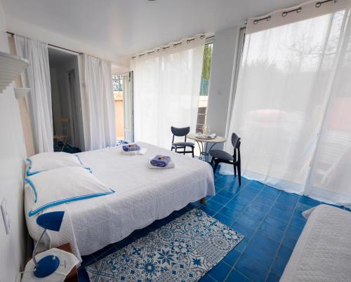 a bedroom with a bed and a table with chairs at Le Jas Du Colombier in Moustiers-Sainte-Marie