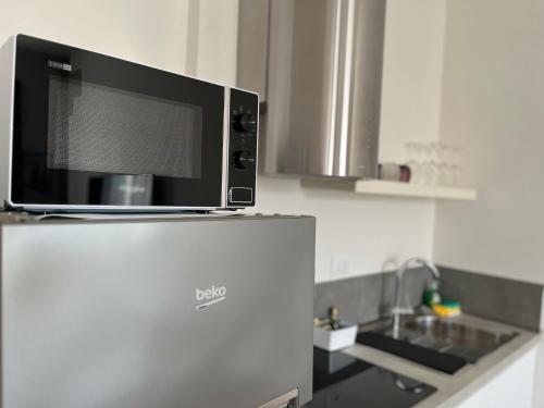 a microwave on top of a refrigerator in a kitchen at sonnino house in Pisa