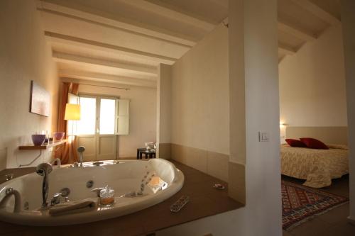 a bath tub in a room with a bedroom at Il Vigneto Resort in Menfi