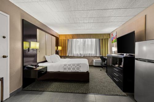 a hotel room with a bed and a desk at Suburban Studios in Altoona