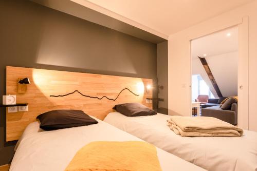 deux lits dans une chambre avec un mur dans l'établissement L'alcôve du Lisey, à Cauterets