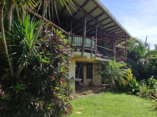 a house with a balcony and some plants at Villa Mango B&B in Nosara