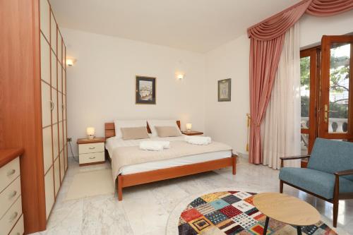 a bedroom with a bed and a blue chair at La casa di Marko in Rabac