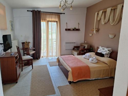 a bedroom with a bed and a desk and a television at Hotel Metoxi in Spiliá